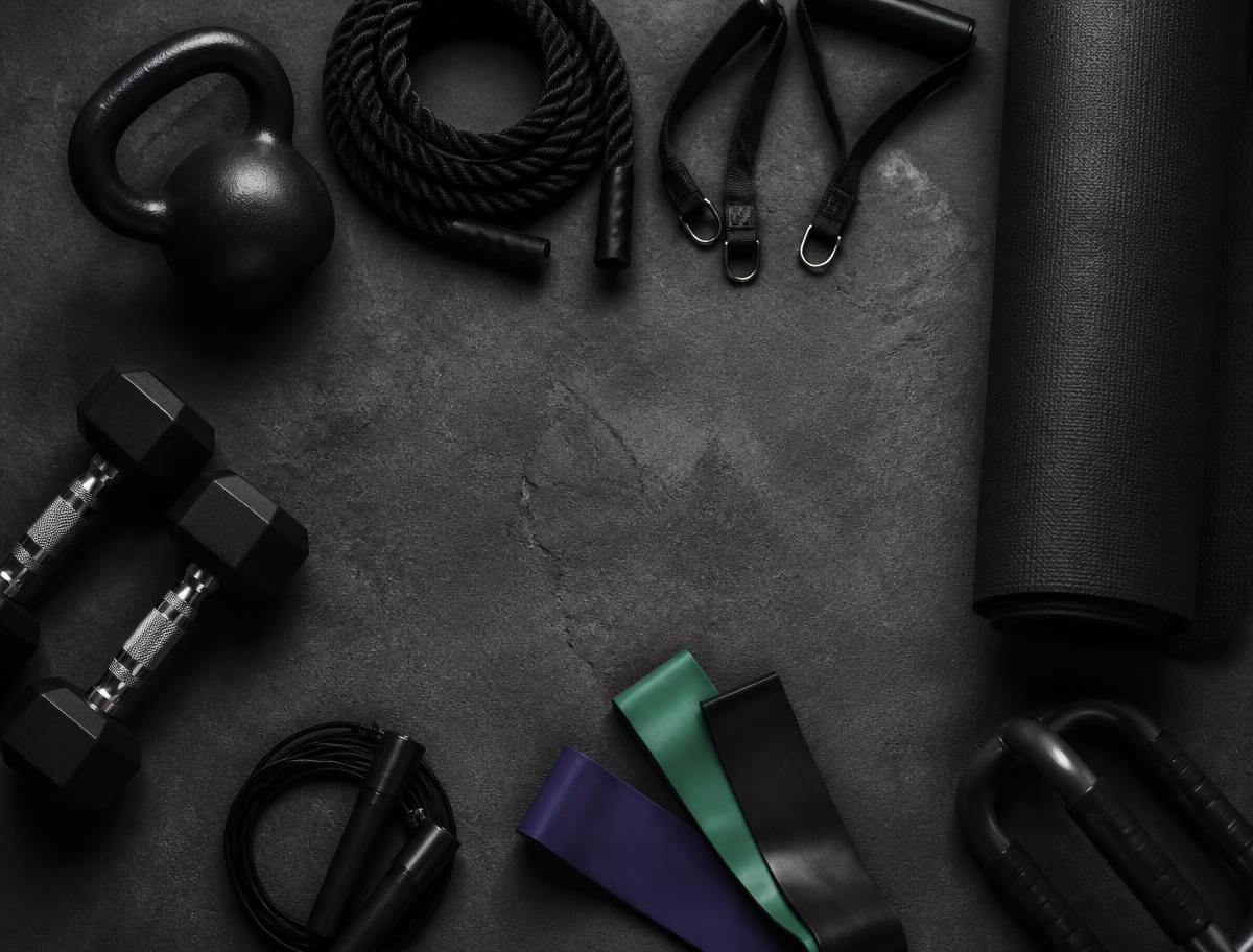 Home gym equipment laid out on concrete